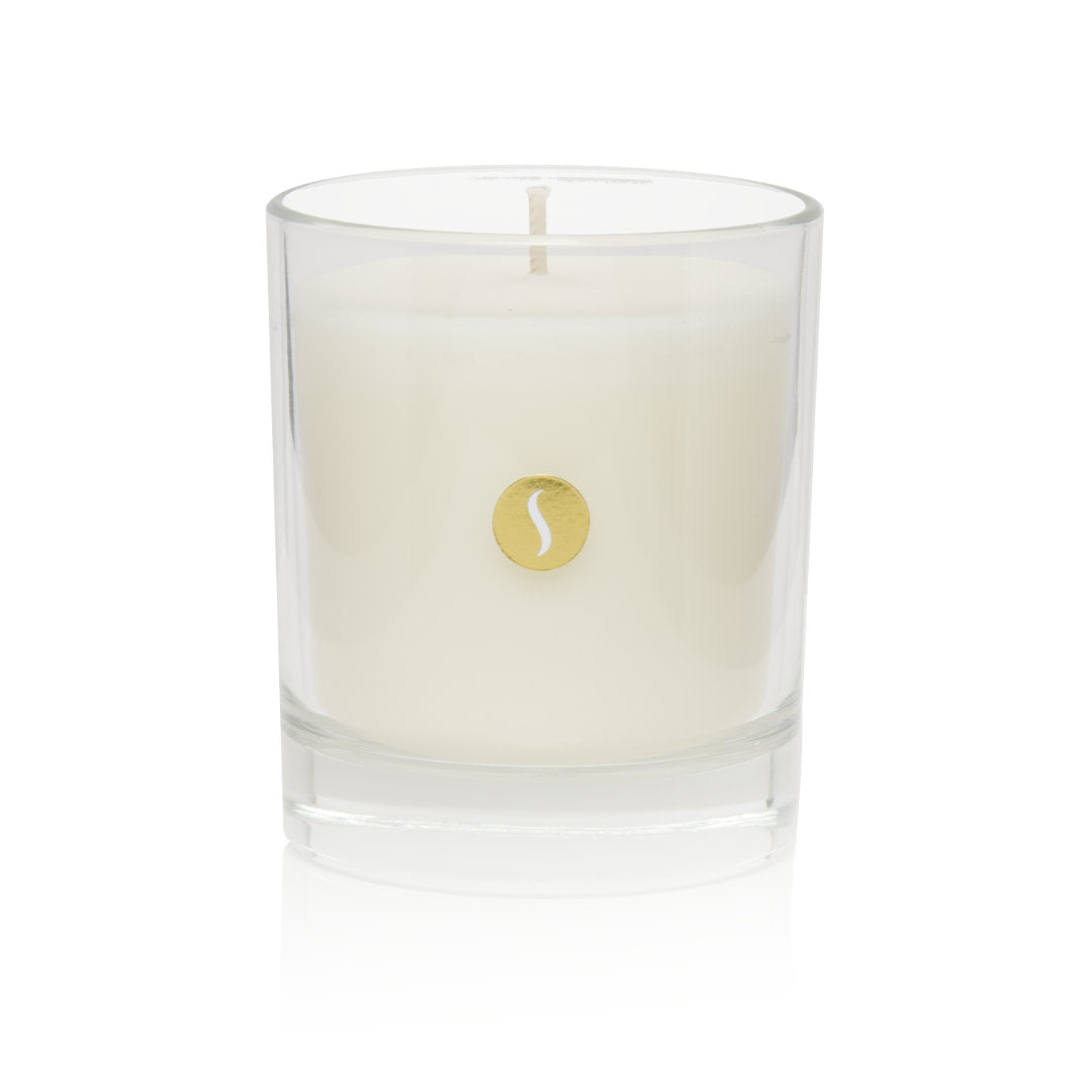 A primary product shot of an unlit SOBOUGIE Blanc Velours luxury scented candle in a clear glass jar with a gold logo medallion, designed for a clean burn and balanced hot throw with a fragrance profile of creamy white musk and amber.