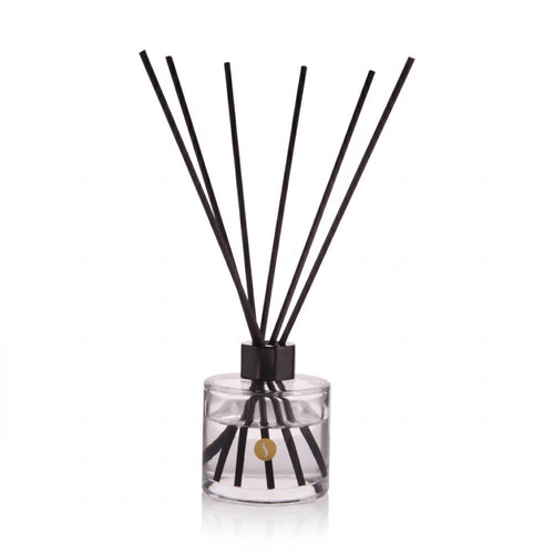 SOBOUGIE Bois Tonka 100ml luxury scented reed diffuser in a clear glass bottle with a gold logo and fanned black reeds, crafted for a balanced, continuous ambient fragrance of native cedarwood and tonka bean.