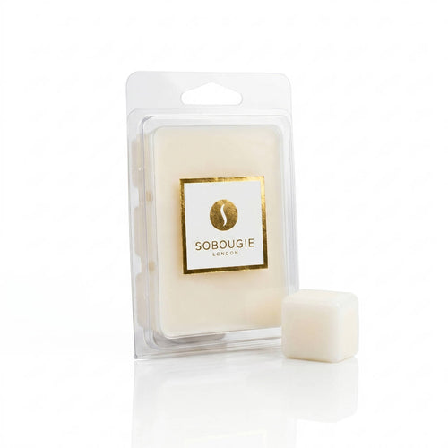 A primary product shot of an 80g SOBOUGIE Bois Tonka luxury scented wax melt clamshell pack alongside an individual wax melt cube, formulated for a clean melt and balanced throw with a grounding fragrance profile of native cedarwood, creamy tonka bean, and clove spice.