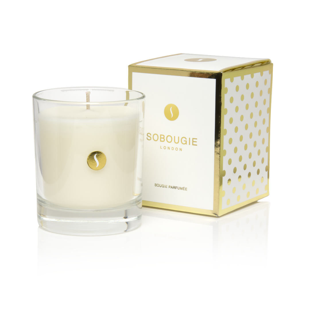 An unlit SOBOUGIE Madame Bougie luxury scented candle in a clear glass jar alongside its white and metallic gold gift box packaging, featuring an elegant fragrance profile of Sicilian orange, fresh rose, jasmine, and warm white musk.